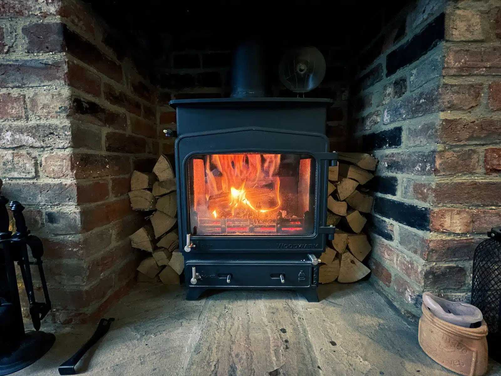 black wood burner near brown brick wall